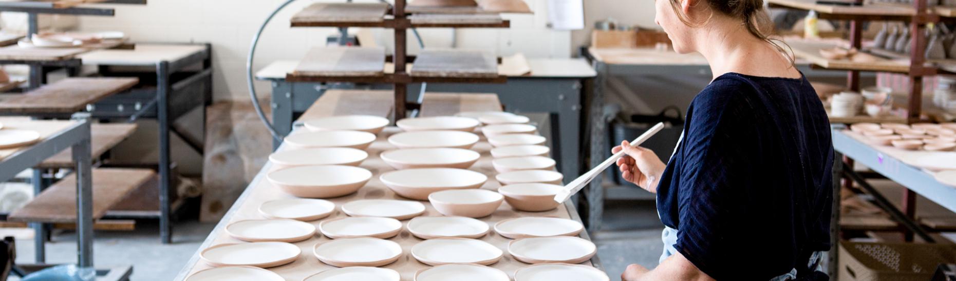 Lady painting ceramic plates