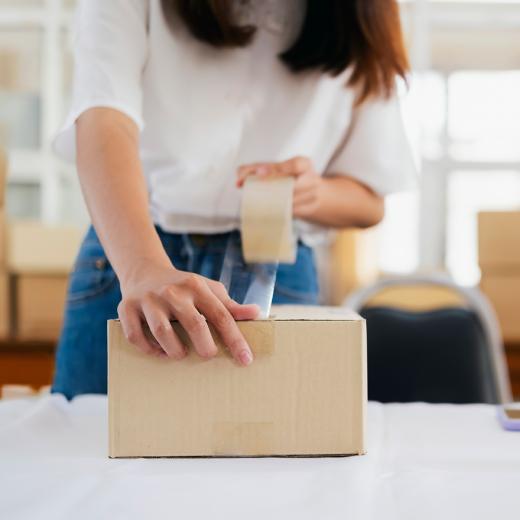 Lady taping carton shut