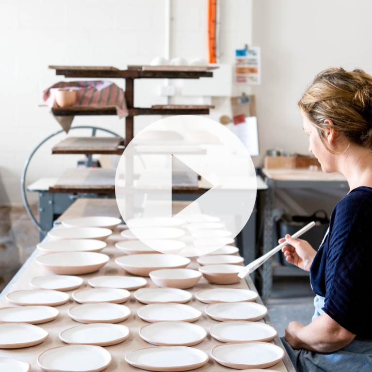 Lady painting ceramic plates