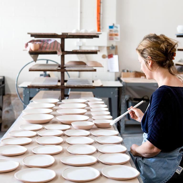 Lady painting ceramic plates