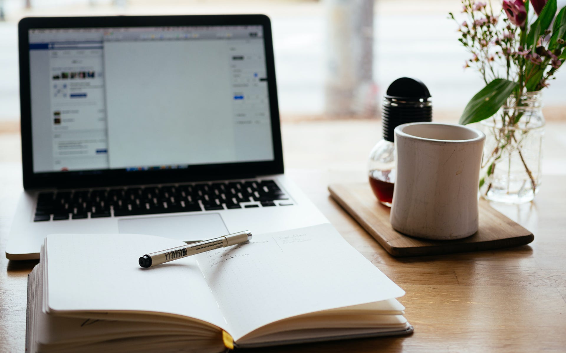 The Image Depicts A Laptop Being Used To Research Aspects Of A Home Online Business, And Notes Being Jotted Down In A Notebook