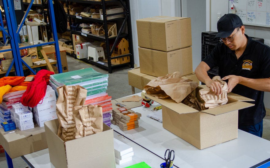 Oskar's Wooden Ark employee void filling cartons with Padpak