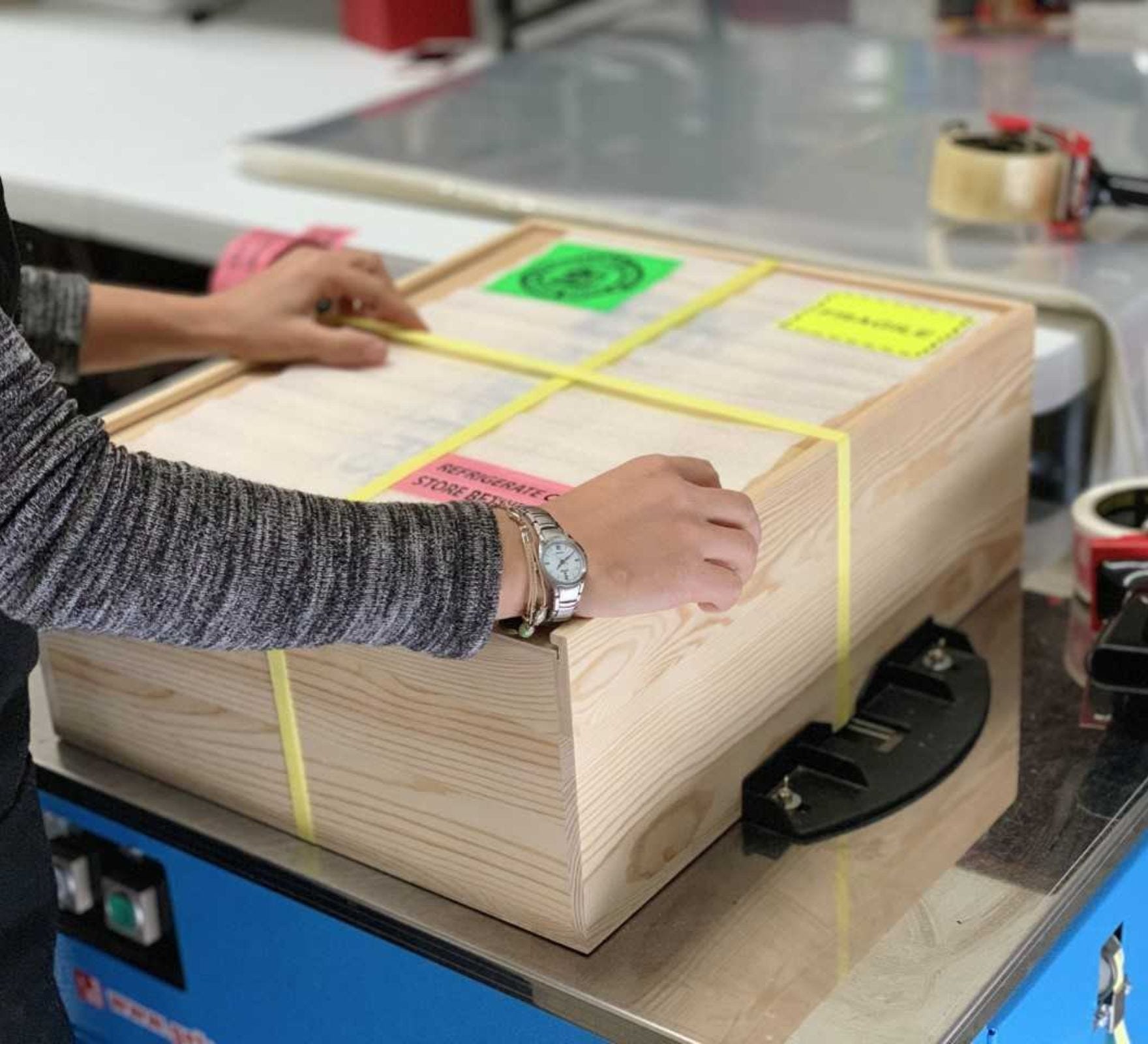 Person Strapping Wooden Box