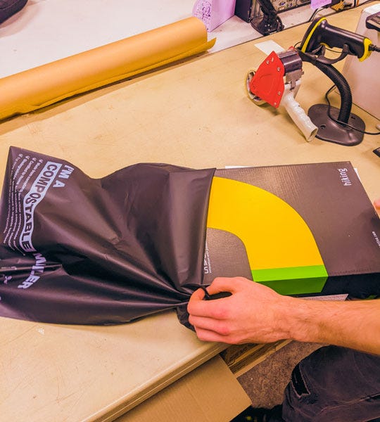 Person wrapping K2 Base Camp product in a Signet Compostable Mailer