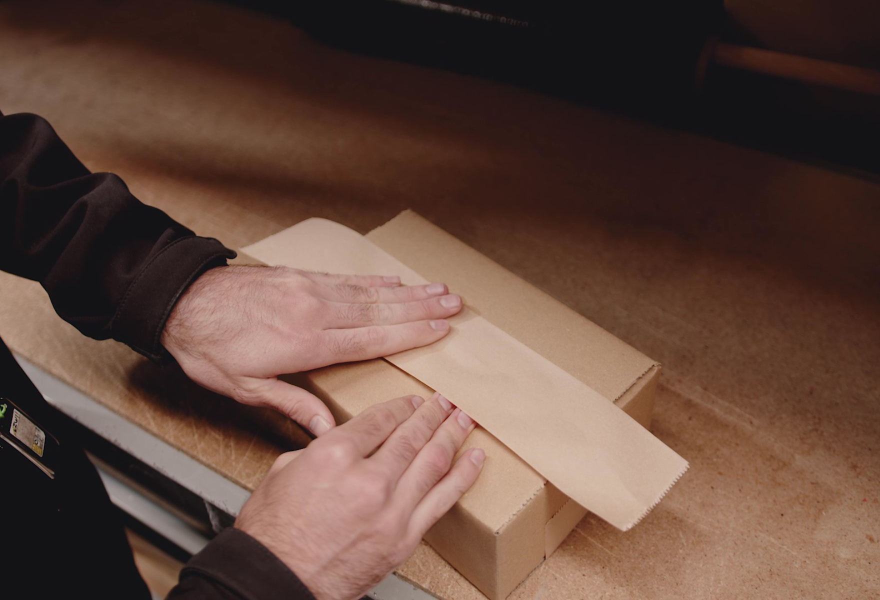 Person sealing a Signet Shipping Box with Water Activated Tape