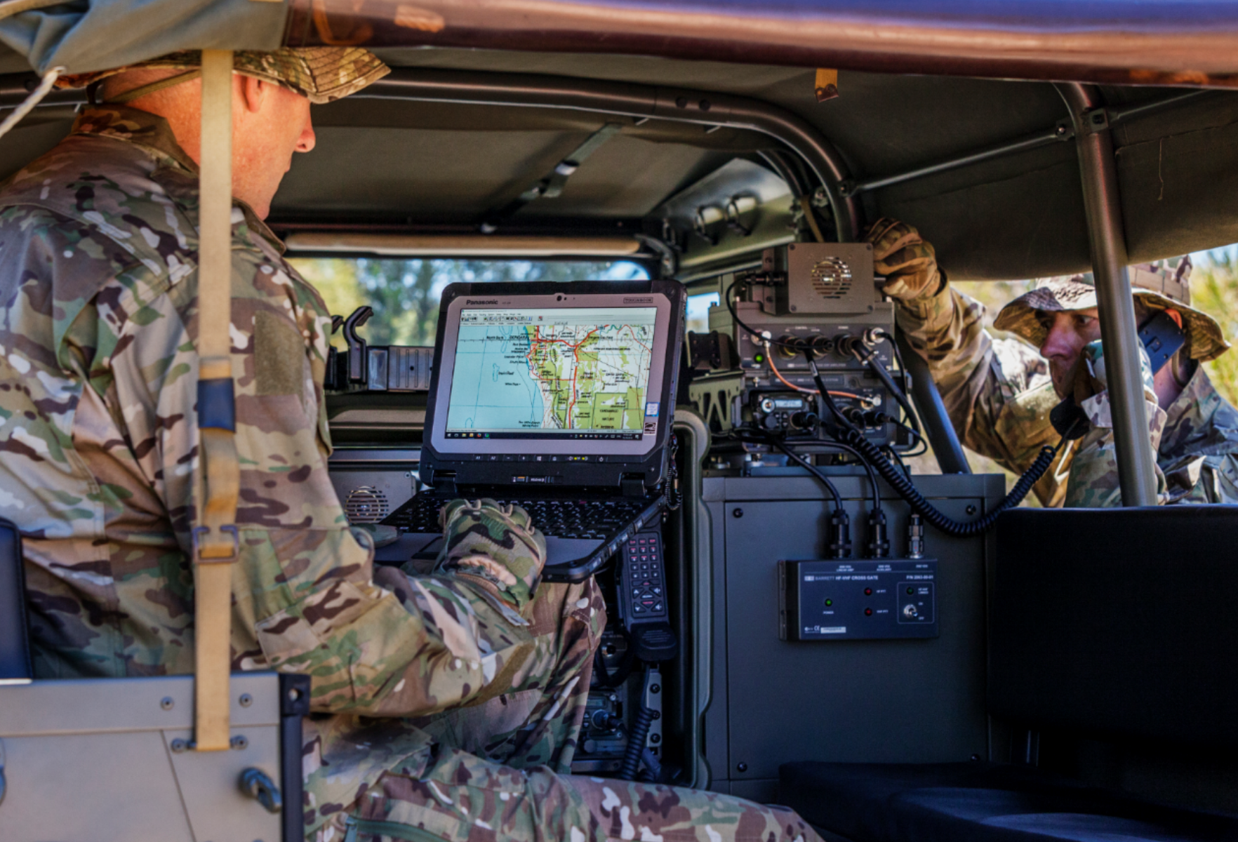 Two Army men using equipment in truck